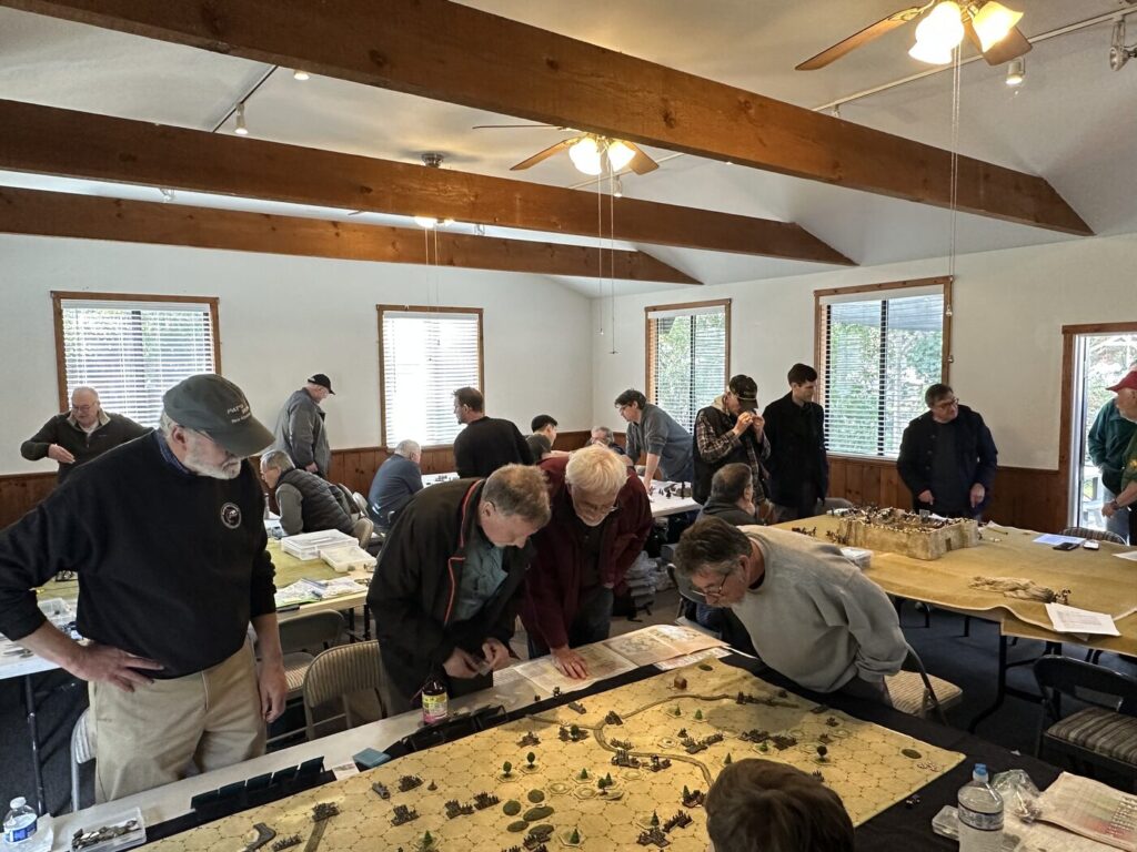 Club members gathered around game tables at a monthly meeting